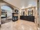 An en-suite bathroom featuring a fireplace, dual vanity, and travertine tile at 18971 E Pinewood Dr, Aurora, CO 80016