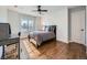 Sunlit bedroom with hardwood floors, modern ceiling fan, and a bright window for natural light at 18971 E Pinewood Dr, Aurora, CO 80016