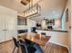 The dining room has a modern table with black chairs and a large industrial chandelier above at 18971 E Pinewood Dr, Aurora, CO 80016