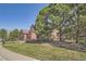 Two-story home with mature trees, lush green lawn, and rock landscaping at 18971 E Pinewood Dr, Aurora, CO 80016
