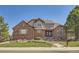 Charming brick two-story home with a well-manicured lawn and garden beds at 18971 E Pinewood Dr, Aurora, CO 80016