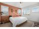 Primary bedroom with large bed and terracotta accent wall at 7880 Horsebrush Ln # A, Littleton, CO 80125