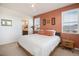 Primary bedroom with large bed, ensuite bathroom access, and terracotta walls at 7880 Horsebrush Ln # A, Littleton, CO 80125