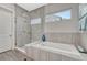 Modern bathroom featuring a glass-enclosed shower and a luxurious soaking tub with sleek tile surround at 4797 Saddle Iron Rd, Castle Rock, CO 80104