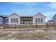 Back exterior view of a bright, modern, white home with a fenced in yard on a sunny day at 4797 Saddle Iron Rd, Castle Rock, CO 80104
