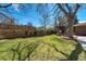 Spacious backyard featuring a lush green lawn, mature trees, and a wooden privacy fence at 590 S Troy St, Aurora, CO 80012