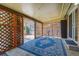 Relaxing covered patio area with decorative lattice, outdoor seating, and a bright blue rug at 590 S Troy St, Aurora, CO 80012
