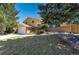 Exterior view of a two-story home with well-maintained landscaping, a driveway, and a welcoming front porch at 590 S Troy St, Aurora, CO 80012