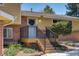 Charming front entrance with steps, black railing, and a decorative wreath, creating a welcoming first impression at 590 S Troy St, Aurora, CO 80012