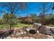 Beautifully landscaped garden area with a stone bird bath, rocks and decorative shrubs at 590 S Troy St, Aurora, CO 80012