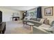 Bright living room featuring a large sectional sofa, neutral carpet, and a large window at 590 S Troy St, Aurora, CO 80012