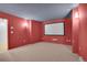 Spacious basement area perfect for recreation, featuring carpeted floors, sconce lighting, and a home theater screen at 20567 E Weaver Dr, Aurora, CO 80016