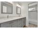 Bathroom with double sinks, marble counters, wood-look floors, and a tiled shower/bath at 20567 E Weaver Dr, Aurora, CO 80016