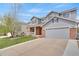 Inviting two-story home showcasing a well-manicured lawn and a paved driveway leading to an attached garage at 20567 E Weaver Dr, Aurora, CO 80016