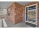 Stylish front entrance with a brick wall, a blue-trimmed storm door, and a textured doormat at 20567 E Weaver Dr, Aurora, CO 80016