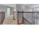 The upstairs hallway showcases a beautiful railing overlooking the main level and plenty of natural light at 20567 E Weaver Dr, Aurora, CO 80016