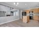 An open-concept kitchen features an island, stainless steel appliances, and light wood cabinets at 20567 E Weaver Dr, Aurora, CO 80016