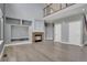 Open-concept living room featuring a cozy fireplace, built-in shelves, and a view of the upper-level landing at 20567 E Weaver Dr, Aurora, CO 80016