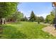 Spacious backyard featuring lush green lawn and mature trees, perfect for recreation and outdoor activities at 24702 E Ontario Dr, Aurora, CO 80016