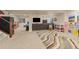 Finished basement with a large sectional, TV, play kitchen and stairs with a gun safe at 24702 E Ontario Dr, Aurora, CO 80016