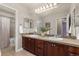 Bathroom featuring a double sink vanity with stone backsplash and a large mirror at 24702 E Ontario Dr, Aurora, CO 80016