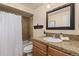 Well-lit bathroom with a vanity, granite countertop, framed mirror, and bathtub with shower at 24702 E Ontario Dr, Aurora, CO 80016