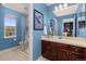 Bright bathroom with blue walls, walk-in shower, and dark wood vanity with a white countertop at 24702 E Ontario Dr, Aurora, CO 80016
