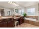 Primary bathroom with double sinks, separate bathtub, and tiled flooring with lots of natural light at 24702 E Ontario Dr, Aurora, CO 80016