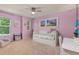 Bright bedroom with pink walls, ceiling fan, and natural light streaming in from the windows at 24702 E Ontario Dr, Aurora, CO 80016