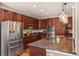 An open kitchen features a stainless steel refrigerator and granite counters with dark cabinetry at 24702 E Ontario Dr, Aurora, CO 80016