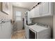 Convenient laundry room with washer, dryer, storage cabinets, and hanging rack at 24702 E Ontario Dr, Aurora, CO 80016