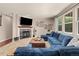 Inviting living room featuring a fireplace, large windows, and a comfortable blue sectional at 24702 E Ontario Dr, Aurora, CO 80016