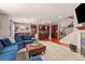 Open-concept living area featuring a comfortable blue sectional sofa, fireplace, and kitchen view at 24702 E Ontario Dr, Aurora, CO 80016