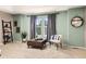 Sitting room with two large windows, green walls, carpet floors, and a plush chair for comfort at 24702 E Ontario Dr, Aurora, CO 80016