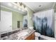 Well-lit bathroom with a decorative shower curtain, vanity with a large mirror, and tile flooring at 72 Rudi W Ln, Golden, CO 80403