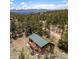 Mountain home featuring a metal roof, wood siding and a large deck with amazing views of the surrounding mountains and forest at 72 Rudi W Ln, Golden, CO 80403