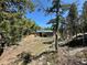 Exterior view of cabin with green roof and beautiful forest surroundings from rocky and wooded vantage point at 72 Rudi W Ln, Golden, CO 80403