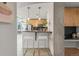 Contemporary kitchen with light wood cabinets, granite countertop, and bar stool seating at 1700 Bassett St # 1111, Denver, CO 80202
