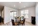 Dining area with a glass-top table, modern chairs, sliding glass doors to the deck, and abundant natural light at 960 S De Gaulle Ct, Aurora, CO 80018