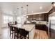 Bright, spacious kitchen with dark wood cabinets, granite countertops, an island with bar seating, and an adjacent dining area at 960 S De Gaulle Ct, Aurora, CO 80018