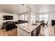 Open-concept kitchen featuring a large granite island, stainless steel appliances, and a seamless flow into the living area at 960 S De Gaulle Ct, Aurora, CO 80018