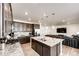 Open-concept kitchen and living area with dark wood cabinets, granite countertops, a kitchen island, and stainless appliances at 960 S De Gaulle Ct, Aurora, CO 80018