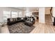 Open-concept living room with a large sectional sofa, plush rug, and seamless flow into the adjacent kitchen at 960 S De Gaulle Ct, Aurora, CO 80018