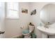 Stylish powder room with a pedestal sink, decorative mirror, and charming wall decor for added appeal at 960 S De Gaulle Ct, Aurora, CO 80018