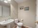 Well-lit half bath includes a pedestal sink, toilet and towel bar at 896 Willow Dr, Brighton, CO 80603
