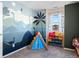 Whimsical bedroom featuring dinosaur-themed decor, a tent, and colorful toy storage at 896 Willow Dr, Brighton, CO 80603