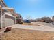 Long driveway leading to a two-car garage in a quiet residential neighborhood at 896 Willow Dr, Brighton, CO 80603