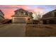 Two-story home with neutral siding, an attached garage, and a well-maintained front yard at sunset at 896 Willow Dr, Brighton, CO 80603