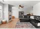 Bright living room with a fireplace, dark sofa, ceiling fan, and wood-look flooring at 896 Willow Dr, Brighton, CO 80603