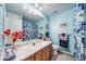 Light blue bathroom featuring a flower-themed shower curtain and decor throughout at 7815 Armadillo Trl, Evergreen, CO 80439